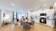 Located at 1000 Sweetbay Haven Ln in Apex, NC, this well-appointed 2-bedroom, 2-bathroom residence offers a thoughtfully designed single-floor layout. The open-concept living, dining, and kitchen area forms the heart of the home, bathed in natural light from multiple windows framed by elegant draping curtains. Light wood flooring flows seamlessly throughout the main living spaces, enhancing the bright, airy atmosphere. Ceiling fans provide added comfort in both the living room and bedrooms.

The kitchen is outfitted with crisp white shaker cabinetry, granite countertops, stainless steel appliances including a refrigerator, range, and microwave, and a pantry for extra storage. The dining area comfortably accommodates a full table and chairs, making it ideal for everyday meals or entertaining.

Both bedrooms feature plush carpeting and ample closet space, with the primary bedroom offering a generously sized layout. The two bathrooms are finished with white cabinetry, granite-topped vanities, and wood-look flooring. One bathroom includes a shower/tub combination, while the other features a walk-in shower. Additional conveniences include in-unit laundry, a utility room, and a private balcony accessible from the living area.