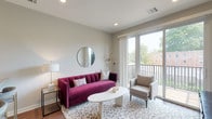 This well-designed single-floor residence offers a thoughtful layout that balances open communal spaces with comfortable private quarters. The living room serves as the centerpiece of the home, featuring warm hardwood-style flooring, recessed lighting, and large sliding glass doors that flood the space with natural light and open directly onto a private balcony with outdoor views of surrounding greenery.

The kitchen is outfitted with crisp white shaker cabinetry, stainless steel appliances including a gas range, built-in microwave, and French door refrigerator, complemented by light granite countertops and a subtle tile backsplash. A peninsula with seating for three provides a casual dining option and keeps the kitchen connected to the living area, reinforcing the open-concept flow throughout.

The bedroom is a calm, light-filled retreat with large windows dressed in white blinds that invite natural daylight. Hardwood-style flooring continues throughout, and neutral wall tones create a serene atmosphere. The full bathroom features a clean, white soaking tub and shower combination with tiled surround and chrome fixtures, offering a straightforward and functional design. Together, the spaces present a cohesive, modern aesthetic well-suited for comfortable everyday living.