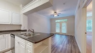 Located on Ewing Street in Houston's 77004 zip code, this single-floor residence offers a well-designed layout that balances comfort and functionality. The kitchen is a standout feature, outfitted with white shaker-style cabinetry, dark granite countertops, a double-basin stainless steel sink, and a full suite of stainless steel appliances including a refrigerator, electric range, over-the-range microwave, and dishwasher. Light-toned tile flooring runs throughout the kitchen, creating a clean and practical workspace. The living area is finished with wood-style plank flooring and accented by crown molding and a ceiling fan with light fixture. French doors with transom windows flood the space with natural light and provide access to the outdoors. The bedrooms feature plush wall-to-wall carpeting, ceiling fans, and windows fitted with blinds that offer views of the surrounding greenery. A carpeted hallway connects the private quarters, lined with six-panel white doors. The bathroom is appointed with a granite-topped vanity, wood-style flooring, a tub-shower combination, and grab bars. Additional rooms with wood-style flooring and crown molding offer versatile living or flex space throughout this thoughtfully finished Houston home.