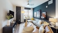This single-floor residence offers a thoughtfully designed layout that balances functionality with contemporary style. The kitchen is outfitted with shaker-style cabinetry in a soft gray finish, white quartz countertops, a subway-tile backsplash, and a full suite of stainless steel appliances, including a gas range, over-the-range microwave, and French door refrigerator. Wood-look flooring anchors the kitchen and flows into the adjacent living area.

The living room features bold teal and charcoal accent walls, a ceiling fan, and multiple windows that invite natural light and outdoor views. A flex room adjacent to the living space mirrors the teal accent wall and offers versatility as a home office or lounge, with carpet flooring and a large window.

The primary bedroom is finished with warm, earthy tones, carpet flooring, and a window with exterior views. It connects to a second bedroom similarly appointed with neutral tones and natural light. A dedicated workspace nook with a large window provides additional flexibility.

Two bathrooms complete the layout. One features deep navy accent walls, a wide vanity with a white countertop, large mirror, and a tiled shower area. The second bathroom includes a tub-shower combination, tile flooring, and a louvered closet door nearby.