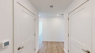 Located at 1001 Birdie Dr in Coraopolis, PA, this single-floor, 4-bedroom, 2-bathroom home offers a thoughtfully designed layout with a clean, modern aesthetic. Warm hardwood-style flooring and crisp white walls are consistent throughout, creating a bright and cohesive atmosphere.

The kitchen is well-appointed with white shaker-style cabinetry extending to the ceiling, light countertops, a stainless steel sink, and a full suite of stainless steel appliances including a refrigerator, range, microwave, and dishwasher. Recessed lighting adds a polished finish to the space.

The bedrooms are generously sized and filled with natural light. Several rooms feature large windows with views of the surrounding neighborhood and greenery. The primary bedroom is notably spacious and includes access to a dedicated walk-in closet outfitted with wire shelving and hanging storage on multiple walls.

Two hallways connect the rooms, lined with clean white panel doors fitted with brushed gold hardware. The bathrooms are finished with white tile tub-surround enclosures, chrome fixtures, and recessed lighting, maintaining the home's consistent, modern style.

Overall, this home presents a fresh, move-in-ready environment with neutral finishes, ample storage, and a functional single-floor layout ideal for comfortable everyday living.