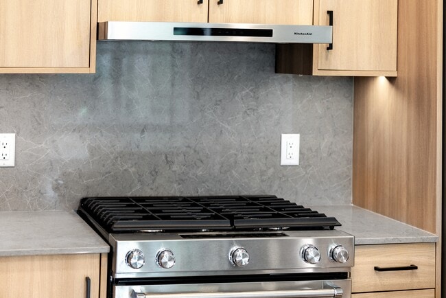 Signature Collection kitchen with stainless steel appliances, quartz countertops, and quartz tile backsplash - Avalon Parsippany
