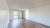 Located at 5474 Reservoir Dr in the College Area neighborhood of San Diego, CA, this single-floor residence offers a clean, modern aesthetic throughout. The open living area is finished with warm wood-style flooring and features a sliding glass door that leads to a private balcony overlooking a serene, tree-lined backdrop, filling the space with natural light. A textured ceiling adds a classic character to the main living areas.

The kitchen is well-appointed with crisp white shaker cabinetry, dark countertops, and a full suite of stainless steel appliances including a refrigerator, dishwasher, electric range, and microwave. Recessed lighting and light wood-style flooring complete the functional yet stylish kitchen layout.

A hallway connects the living spaces to the bedroom, which is carpeted for comfort and includes a window that invites in natural light. The bathroom features a wide dark-countered vanity with dual undermount sinks, white cabinetry, a large wall mirror, and a tub-shower combination. Throughout the residence, a consistent palette of white walls and neutral tones creates a bright, cohesive ambiance suited to a variety of interior styles.