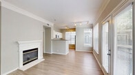 Located in Houston's vibrant Midtown neighborhood, this 2-bedroom, 2-bathroom residence offers a well-designed single-floor layout filled with natural light. Light wood-look flooring runs throughout, complementing the neutral color palette and crown molding found in the main living areas.

The open-concept living room is anchored by a classic white fireplace and flows seamlessly into the dining area and kitchen. The kitchen features a peninsula with dark countertops, stainless steel appliances including a full-size refrigerator, white cabinetry, and track lighting overhead. An adjacent pantry adds convenient storage.

French doors in the living room and large windows across the unit invite generous natural light and outdoor views. Both bedrooms are well-proportioned, each equipped with a ceiling fan and large windows. The spacious primary bedroom connects to a private bathroom featuring a single vanity with granite-style countertop, a soaking tub, and a walk-in closet with wire shelving. A second full bathroom serves the additional bedroom and guests.

A dedicated in-unit laundry room with washer and dryer hookups adds everyday convenience. With four closets total, two hallways, and a welcoming entrance, the layout maximizes functionality and livability throughout.