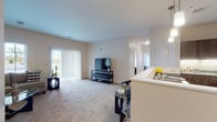 This single-floor residence offers a thoughtfully designed open-concept layout that seamlessly connects the living, dining, and kitchen areas. The spacious living room features neutral-toned carpet, large windows, and a sliding glass door fitted with vertical blinds that invite abundant natural light while providing views of the surrounding outdoor scenery. The kitchen is outfitted with dark wood cabinetry, granite countertops, stainless steel appliances including a refrigerator, range, and microwave, and light hardwood-style flooring that adds warmth to the space. A breakfast bar peninsula connects the kitchen to the main living area, enhancing the open feel.

Both bedrooms are comfortably sized with plush carpeting and bright windows that frame outdoor views, offering a calm and restful atmosphere. Each bathroom is finished with wood-tone vanity cabinetry, granite countertops, a large mirror, and hardwood-style tile flooring. The bathrooms include a tub-shower combination, providing functional and polished spaces. Throughout the residence, neutral wall tones and consistent finishes create a cohesive, welcoming ambiance suited for everyday living.