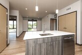 This contemporary 2-bedroom, 4-bathroom unit offers a well-designed single-floor layout with a clean, modern aesthetic throughout. Light hardwood flooring flows seamlessly across all living areas, complementing the crisp white walls and creating a bright, cohesive feel.

The open-concept kitchen is a standout feature, anchored by a central island with a white quartz countertop, an undermount sink, and warm wood cabinetry. Pendant lighting hangs above the island, adding a stylish touch. The kitchen is fully equipped with stainless steel appliances, including a refrigerator, electric range, microwave, and dishwasher. The kitchen opens directly into the living area, making it ideal for entertaining.

Both bedrooms are well-proportioned, each featuring large black-framed windows that allow generous natural light and offer views of the surrounding neighborhood. Exposed metallic ductwork runs along the ceilings, lending an industrial-modern character to the rooms.

The four bathrooms are finished with a consistent modern palette — wood-tone vanities, white quartz countertops, framed mirrors, and light hardwood-style flooring. One bathroom includes a shower-tub combination, while others feature walk-in style shower areas.

Additional details include recessed lighting throughout, a large double-door closet near the entry, and a functional, efficiently organized floor plan that maximizes the available space.
