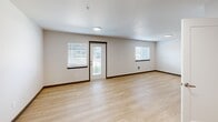 Located at 1360 Wendell Ave SE in Port Orchard, Washington, this well-designed single-floor residence makes smart use of its compact footprint. Light-toned hardwood-style flooring runs throughout, lending warmth and visual continuity to every room.

The open-concept kitchen and dining area is a standout feature, outfitted with stainless steel appliances—including a full-size refrigerator, electric range, and built-in microwave—complemented by taupe cabinetry, white quartz countertops, and a stainless steel undermount sink. A peninsula counter provides additional prep space and casual dining. A dedicated pantry offers generous storage to keep the kitchen organized.

The living room is bright and welcoming, benefiting from multiple windows and a glass-panel entry door that invites natural light and provides outdoor views. The clean, neutral walls and open layout offer flexibility for a variety of furniture arrangements.

The bathroom features a tub-shower combination with a curved curtain rod, white tile surround, and light wood-tone flooring. Conveniently adjacent to the bathroom is an in-unit laundry closet housing a stacked washer and dryer. Two additional closets provide practical storage throughout the unit.

The overall ambiance is clean, modern, and move-in ready, with consistent finishes that create a cohesive and functional living environment.