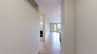 Located at 3459 Butler Street in Pittsburgh's vibrant Lawrenceville neighborhood, this well-appointed 2-bedroom, 2-bathroom unit offers a thoughtfully designed single-floor layout. The open-concept kitchen and living area serves as the heart of the home, featuring rich dark-stained cabinetry, granite countertops, a subway tile backsplash, stainless steel appliances, and a central island with a built-in sink illuminated by stylish pendant lighting. Light wood-style flooring flows throughout the main living area, enhancing the bright, airy atmosphere. Glass doors lead to a private balcony, allowing natural light to fill the space. The primary bedroom includes plush carpeting, a dedicated closet with built-in shelving, and direct access to an en-suite bathroom. The second bedroom, also carpeted, features a clerestory window that brings in additional natural light. Both bathrooms are finished with tile flooring, full tub-shower combinations, and dark vanities topped with granite countertops. Additional storage is provided by two closets and a utility room, rounding out this functional and comfortable urban residence.