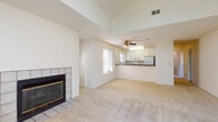 Located at 313 Twinbridge Circle in Pleasant Hill, CA, this single-story residence offers a thoughtfully designed layout with distinct architectural details throughout. The living room immediately draws attention with its soaring vaulted ceilings and a striking arched window positioned high on the wall, flooding the space with natural light. A second large window and a tile-surround fireplace with glass doors add warmth and character, while plush carpeting extends throughout the living and bedroom areas. A ceiling fan provides both function and comfort.

The kitchen opens directly to the living area via a raised breakfast bar, creating a connected, open feel. White cabinetry, dark granite-style countertops, hardwood-style flooring, and multiple windows contribute to a bright and functional workspace. White appliances complete the setup.

The bedrooms are generously proportioned with carpet flooring, natural light from individual windows, and built-in closet storage. The bathroom features a full tub-shower combination, dark countertop vanity with an undermount sink, and hardwood-style flooring. A laundry area with access doors rounds out the home's practical amenities, making this a well-equipped and light-filled residence.