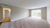 Located at 16W571 Mockingbird Ln in Willowbrook, Illinois, this single-floor residence offers a well-organized layout with a cohesive neutral color palette throughout. The spacious living area is finished with plush wall-to-wall carpeting and features a large sliding glass door with vertical blinds that floods the room with natural light and provides views of the surrounding greenery. An adjacent entry area with hard surface flooring connects seamlessly to the rest of the home. The kitchen is thoughtfully designed with white shaker-style cabinetry, light granite countertops, a stainless steel sink, and stainless steel appliances, all complemented by durable wood-look plank flooring. Multiple bedrooms are carpeted and well-proportioned, each benefiting from windows with blinds that bring in natural light. The primary bedroom includes access to a closet and a connected hallway leading to additional rooms. At least one bedroom features a built-in closet with bifold doors. The bathroom is equipped with a full soaking tub and shower surrounded by warm-toned tile, paired with wood-look flooring and clean white fixtures. Overall, the space presents a clean, move-in ready environment with consistent finishes throughout.