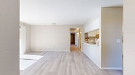 Located at 43230 Gadsden Ave in Lancaster, CA, this single-story, 4-bedroom, 2-bathroom home offers a well-organized and functional layout. The open-concept living and dining area is finished with light wood-style flooring and neutral warm beige walls, creating a bright and welcoming atmosphere. Sliding glass doors flood the living space with natural light and provide access to an outdoor patio with tree-lined views. The kitchen features white cabinetry, a stainless steel sink, light stone countertops, a breakfast bar peninsula, and white appliances including a range and refrigerator — offering both practicality and a clean aesthetic. A hallway connects the main living areas to the four bedrooms, each carpeted for comfort. The primary bedroom is generously sized and includes dedicated closet space. Additional bedrooms are well-proportioned, each with natural light from windows and sliding closet doors. With a total of six closets throughout the home, storage is plentiful. The two bathrooms are finished in neutral tones, with one featuring a glass-enclosed walk-in shower. Ceiling fans in the bedrooms add to the home's comfort. The layout flows efficiently, making this a practical and comfortable single-floor residence.