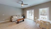 Located at 150 Autumn Creek Ln in East Amherst, NY, this well-appointed single-floor residence offers a cohesive, neutral color palette with warm taupe walls, crisp white trim, and light wood-style flooring throughout the main living areas. The kitchen is outfitted with white shaker-style cabinetry, granite countertops, and a full suite of stainless steel appliances including a gas range, built-in microwave, and refrigerator, making it both functional and visually appealing. The open living area features light-toned flooring, a ceiling fan, and large sliding glass doors that invite natural light and provide direct views of the surrounding wooded landscape. The bedrooms are finished with plush carpeting and large windows that frame serene outdoor scenery, offering a comfortable and restful atmosphere. One bedroom includes a spacious double-door closet, providing ample storage. The bathrooms are tastefully designed with granite-topped white vanities, light wood-style tile flooring, and chrome fixtures. A full bath features a tiled soaking tub and shower combination, while a separate half bath offers a round mirror and refined accents. The overall design is clean, modern, and move-in ready, with consistent finishes that create a polished, harmonious living environment.
