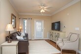 Located on Eastland Court SE in Rome, Georgia, this single-floor residence offers a thoughtfully designed layout that balances comfort and functionality. The living room serves as the heart of the home, featuring elegant crown molding, hardwood-style flooring, a ceiling fan, and large windows dressed with grommet-top curtains that allow natural light to fill the space. A welcoming entry door adds direct accessibility to this area.

The kitchen is outfitted with white cabinetry extending to the ceiling for ample storage, light stone-look countertops, stainless steel appliances including a refrigerator, electric range, and microwave, and hardwood-style flooring. It connects seamlessly to a dedicated dining area, creating a practical and sociable layout ideal for everyday living and entertaining.

The residence includes multiple bedrooms, each finished with neutral tones, plush carpeting, ceiling fans, and natural light from well-placed windows. The primary bedroom is generously proportioned and features multiple windows, while the secondary bedrooms are equally well-appointed with coordinating rustic wood furniture and warm ambient lighting.

The bathroom features a clean, white vanity with stone-look countertops, a lighted mirror, and hardwood-style flooring. Crown molding and consistent neutral tones throughout the home contribute to a cohesive and welcoming ambiance.