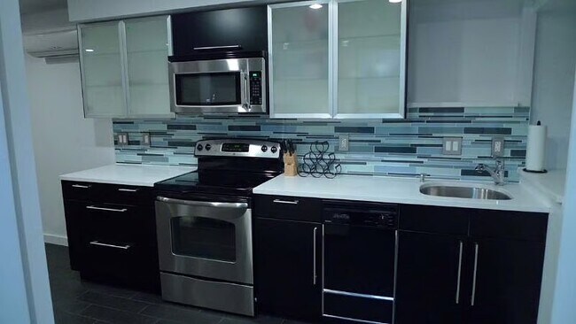 Cocina completa equipada con utensilios, ollas/sartenes, vajilla, lavavajillas y triturador de basura. - 2300 Ontario Rd NW
