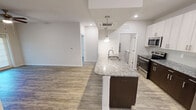 This contemporary 910 square foot apartment in Charlotte, NC offers a harmonious blend of style and functionality. The heart of the home is a striking kitchen, featuring a two-tone design with white upper cabinets and dark lower cabinets, complemented by speckled granite countertops. Stainless steel appliances, including a built-in microwave, add a modern touch.

The living area is spacious and bright, with wood-look flooring that extends throughout the apartment. French doors lead to an outdoor space, allowing natural light to flood the room. A ceiling fan provides comfort and air circulation.

The apartment boasts three bedrooms, including a primary bedroom of 160 square feet. Each room features the same stylish flooring and neutral wall colors, creating a cohesive look. The bathroom showcases a granite-topped vanity with ample storage and a large mirror.

Storage solutions are plentiful, with a walk-in closet offering built-in shelving and hanging space. The laundry area comes equipped with a washer and dryer for added convenience.

Recessed lighting throughout adds to the modern ambiance, while the open floor plan enhances the sense of space. This well-designed apartment offers a perfect balance of comfort and contemporary living in its 910 square feet.