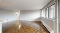 This contemporary apartment, located at 10 Roanoke Rd in Toronto, offers a well-designed living space of 102 square meters. The single-floor layout comprises three bedrooms, including a generously sized primary bedroom of 19 square meters, and two bathrooms. The heart of the home is an open-concept kitchen and living room area, perfect for entertaining or relaxing.

Throughout the apartment, beautiful parquet flooring adds warmth and character. Large windows in the living area and bedrooms flood the space with natural light and offer views of the surrounding area. A standout feature is the balcony, providing an outdoor retreat with scenic vistas of the nearby wooded landscape.

The bathrooms are fitted with modern fixtures, including a vanity with a sleek marble-like countertop and ample storage. The kitchen, while not fully visible in the images, appears to have clean, white cabinetry consistent with the apartment's contemporary aesthetic.

Additional amenities include a separate laundry area for convenience. The apartment's neutral color palette and minimalist design create a blank canvas for personal style while maintaining a sophisticated ambiance. With its thoughtful layout and modern touches, this apartment offers a comfortable and stylish urban living experience in Toronto.