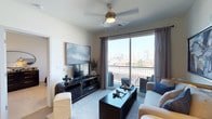 This single-floor residence at Main & Clay offers a thoughtfully designed layout with modern finishes throughout. The living room serves as the heart of the home, featuring a ceiling fan, plush carpeting, and a large sliding glass door that opens onto a private balcony with sweeping city skyline views. Natural light fills the space, creating a bright and inviting atmosphere.

The kitchen is outfitted with a bold two-tone design, pairing dark lower cabinets with white upper cabinetry and clean white countertops. Stainless steel appliances, including a range and over-the-range microwave, complete the functional and stylish cooking space.

The primary bedroom is generously sized with carpet flooring, a ceiling fan, and windows that invite natural light. It connects to a well-appointed en-suite bathroom featuring a glass-enclosed shower, white vanity, and tile flooring, alongside a spacious walk-in closet with built-in shelving. A second bedroom offers similar comfort with natural light and easy access to a full bathroom equipped with a tub-shower combination, white vanity, and tile floors. The overall ambiance is clean, contemporary, and urban.