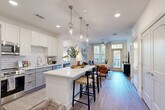 Located at 368 Sublime Summer Lane in Clover, SC, this thoughtfully designed 2-bedroom, 2-bathroom residence offers a comfortable and stylish single-floor layout. The open-concept kitchen and living area serves as the heart of the home, featuring white upper cabinetry, gray lower cabinets, a classic subway tile backsplash, stainless steel appliances, and a white quartz waterfall island with bar seating illuminated by sleek pendant lighting. Wood-look flooring flows throughout, tying the spaces together seamlessly. The living room is bright and inviting, with large windows that welcome abundant natural light, a ceiling fan, and direct access to a private balcony. Both bedrooms are well-sized, offering generous closet space — including a spacious walk-in closet — ceiling fans, and large windows with outdoor views. The primary bathroom features gray cabinetry, a white quartz vanity, and a glass-enclosed shower. Additional conveniences include a dedicated laundry area, a utility room, and ample built-in storage throughout. The clean, neutral palette and modern finishes create a bright, cohesive ambiance ideal for everyday living.