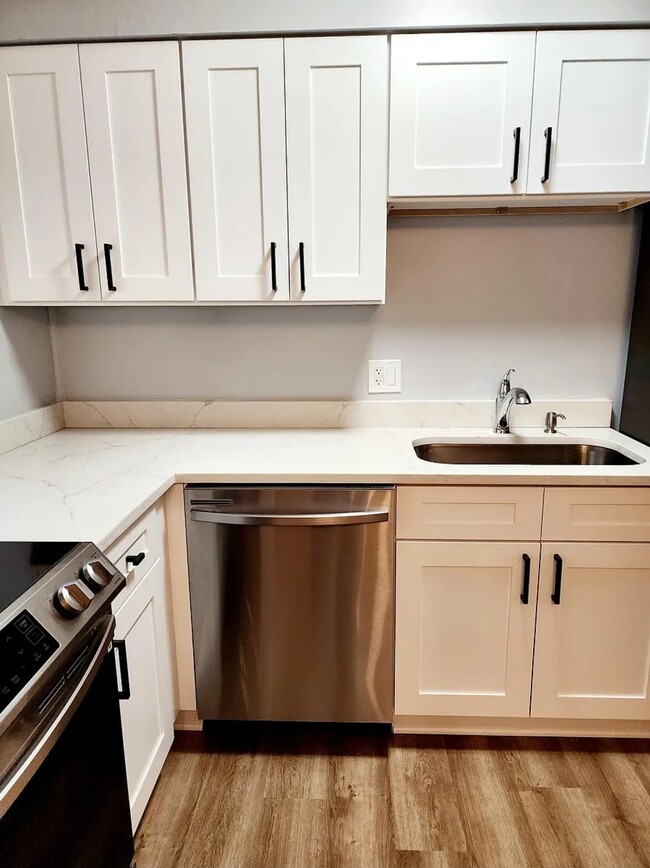 The bright L-shaped kitchen layout offers generous cabinetry, stainless appliances, and stylish fini - 21 Richmond Sq
