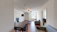 Located at 800 W Hovey Ave, Unit 312 in Normal, IL, this well-appointed two-bedroom, three-bathroom unit offers a functional and comfortable layout across a single floor. The open-concept living and kitchen area is anchored by warm hardwood-style flooring and a ceiling fan, creating an inviting atmosphere. The kitchen is a standout feature, boasting rich wood cabinetry, granite-style countertops, a central island ideal for meal prep or casual dining, and black appliances including a range and full-size refrigerator. The living room provides ample space for relaxing or entertaining, complete with a wall-mounted TV mount and access to adjoining rooms. Both bedrooms are carpeted for comfort, offering a quieter, cozier feel. The primary bedroom is generously sized and includes a double-door closet and a private en-suite bathroom. The additional bedroom also features closet space and natural light from a window. The three bathrooms are clean and functional, with at least one featuring a tiled tub-shower combination and wood-tone flooring. Wood-toned cabinetry in the bathrooms ties the design together cohesively throughout the unit.