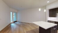 Located at 1540 Vine St in the heart of Hollywood, Los Angeles, this single-floor residence offers a thoughtfully designed open-concept layout with clean, modern finishes. Wide-plank light hardwood flooring flows throughout the main living areas, complementing the bright white walls and creating a warm, contemporary ambiance.

The kitchen is a standout feature, outfitted with dark espresso cabinetry, a crisp white countertop island with pendant lighting, a mosaic tile backsplash, and a full suite of stainless steel appliances including a refrigerator, range, and microwave. A dedicated in-unit stacked washer and dryer adds everyday convenience.

The open living area is bathed in natural light and provides direct access to a private outdoor balcony through glass-paneled doors, offering views of the surrounding neighborhood. Pendant lighting over the kitchen island extends into the living space, enhancing the modern aesthetic.

The bedroom is generously proportioned with plush carpet flooring, high ceilings, and access to a walk-in closet with built-in shelving. The bathroom is finished with classic penny tile flooring, a dark wood vanity with a white basin, a full-size soaking tub with a sliding glass enclosure, and a large frameless mirror — completing this well-appointed Hollywood residence.