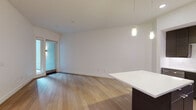 Located at 1540 Vine St in the heart of Hollywood, Los Angeles, this single-floor residence offers a thoughtfully designed open-concept layout with clean, modern finishes. Wide-plank light hardwood flooring flows throughout the main living areas, complementing the bright white walls and creating a warm, contemporary ambiance.

The kitchen is a standout feature, outfitted with dark espresso cabinetry, a crisp white countertop island with pendant lighting, a mosaic tile backsplash, and a full suite of stainless steel appliances including a refrigerator, range, and microwave. A dedicated in-unit stacked washer and dryer adds everyday convenience.

The open living area is bathed in natural light and provides direct access to a private outdoor balcony through glass-paneled doors, offering views of the surrounding neighborhood. Pendant lighting over the kitchen island extends into the living space, enhancing the modern aesthetic.

The bedroom is generously proportioned with plush carpet flooring, high ceilings, and access to a walk-in closet with built-in shelving. The bathroom is finished with classic penny tile flooring, a dark wood vanity with a white basin, a full-size soaking tub with a sliding glass enclosure, and a large frameless mirror — completing this well-appointed Hollywood residence.