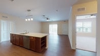 Located at 20 House Ave in Camp Hill, Pennsylvania, this single-floor residence offers a well-designed, open-concept layout that maximizes functionality and comfort. The kitchen is a standout feature, outfitted with rich dark cabinetry, stainless steel appliances including a refrigerator, range, and over-the-range microwave, white quartz-style countertops, a subway tile backsplash, and a central island with pendant lighting and built-in shelving. The kitchen flows seamlessly into a generously sized living area with hardwood-style flooring, crown molding, a ceiling fan, and access to an outdoor balcony through sliding glass doors. The bedroom is carpeted and bright, featuring a ceiling fan and natural light from a large window with exterior views. The bathroom is well-appointed with a vessel sink atop a dark wood vanity, white countertop, a framed mirror with overhead vanity lighting, and tile flooring. A half bath with tile flooring provides additional convenience. The dedicated laundry room houses a full-size washer and dryer with overhead wire shelving for storage. Throughout the residence, warm neutral tones and consistent finishes create a cohesive and inviting atmosphere.