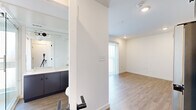 Located in Austin, TX, this thoughtfully designed studio offers a compact yet functional single-floor layout comprising a bedroom, kitchen, and bathroom. The interior features a clean, modern aesthetic characterized by crisp white walls, light wood-style flooring, and recessed lighting throughout.

The kitchen is a standout feature, showcasing a two-tone design with slate-blue lower cabinets and white upper cabinets, all paired with white countertops. A full suite of stainless steel appliances includes an electric range, over-the-range microwave, and dishwasher, making the kitchen both stylish and highly functional.

The bedroom area benefits from generous natural light provided by a large double window dressed with white horizontal blinds, offering views of the surrounding neighborhood. The open layout between the sleeping area and common spaces maximizes the efficient use of the floor plan.

The bathroom is elegantly appointed with a glass-enclosed walk-in shower featuring floor-to-ceiling marble-look tile, a built-in bench, and a frosted privacy window that allows natural light to filter in. Dark cabinetry beneath a white vanity countertop ties in seamlessly with the kitchen's design palette.

Overall, the space presents a cohesive, contemporary feel with a neutral color palette and modern finishes, offering a well-equipped and efficiently planned living environment in Austin's 78741 area.