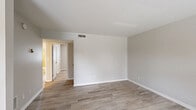 This one-bedroom, one-bathroom apartment at 1915 Rockford Lane in Shively, Kentucky offers a clean, functional layout across a single floor. The interior is finished with light-toned luxury vinyl plank flooring throughout, paired with neutral gray-beige walls and crisp white trim, creating a bright and cohesive aesthetic.

The living room serves as the main gathering space, featuring multiple windows with blinds that allow ample natural light, a ceiling fan, and a bold black front door that adds a subtle contrast to the otherwise soft color palette. The space flows naturally into a dedicated dining area and a separate kitchen, providing clear distinctions between living and meal-prep zones.

The bedroom is a well-proportioned retreat with a window overlooking the outdoors, light flooring, and direct access to the full bathroom. The bathroom features white cabinetry, a vanity with sink, and a toilet, maintaining the clean, practical design found throughout the unit. Three closets provide generous storage options across the space.

Ceiling-mounted light fixtures are present in key rooms, and HVAC vents are integrated throughout for year-round comfort. The overall ambiance is fresh and move-in ready, with a minimalist design that offers a versatile canvas for personalization.