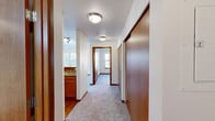 Located in SeaTac, WA, this two-bedroom, one-bathroom residence offers a thoughtfully laid-out single-floor plan with a comfortable and functional design. The interior is unified by warm wood-toned trim, doors, and cabinetry that contrast cleanly against neutral, light-colored walls and soft carpeting found throughout the bedrooms and main living areas.

The combined dining and living room serves as the central gathering space, benefiting from multiple windows fitted with vertical blinds that allow ample natural light to filter in. A private balcony extends the living area outdoors. The kitchen features wood cabinetry paired with granite-style countertops, providing a practical workspace.

The two bedrooms are well-proportioned, each with carpeted floors, vertical blind-covered windows, and warm wood baseboards. The primary bedroom offers a generous footprint with good natural light. Three closets throughout the unit provide substantial storage capacity.

The bathroom is finished with wood-look vinyl flooring, a wood-vanity with a granite-style countertop, and a full tub-shower combination. A dedicated laundry area adds everyday convenience. A central hallway connects all rooms efficiently, finished consistently with the unit's warm, cohesive aesthetic. Overall, the space presents a clean, practical, and inviting environment.