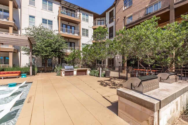 Lujosa terraza en la piscina con área de comedor al aire libre y estaciones de parrilla estilo centro turístico - The Austin at Trinity Green