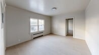 Located at 1312 Cleveland Avenue Northwest in Canton, Ohio, this single-floor, one-bedroom, one-bathroom unit offers a clean and functional layout designed for comfortable everyday living. Light wood-style flooring runs throughout, tying the space together with a bright, cohesive look.

The living room is a welcoming open area bathed in natural light from large windows, complemented by a baseboard radiator heating system. Neutral gray-white walls and a flush ceiling light fixture contribute to the room's airy, understated ambiance. The entrance opens directly into this main living area, which flows naturally into the rest of the unit.

The kitchen is efficiently designed with crisp white shaker-style cabinetry, stone-look countertops, and a classic tile backsplash. Stainless steel appliances — including a full-size refrigerator, range, and over-the-range microwave — provide a modern, functional cooking space.

The bedroom is a generously proportioned room featuring the same light flooring, neutral walls, natural window light, and a radiator, with two closets providing ample storage. A hallway connects the bedroom to the rest of the unit, maintaining a practical flow.

The bathroom is finished in an all-white palette with subway tile surrounding the shower-tub combination, a pedestal-style vanity with mirror, and a bright window that allows natural light in. The overall space presents a clean, move-in ready environment with a timeless, simple aesthetic.