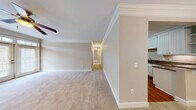 Located at 1050 Greystone Summit Dr in Cumming, GA, this well-appointed single-floor home offers three bedrooms, two bathrooms, and a thoughtful layout designed for comfortable living. The open living and dining area is accented with elegant crown molding, a ceiling fan, and plush carpeting, creating a warm and inviting atmosphere. The dining space features classic wainscoting and a decorative chandelier, adding a touch of traditional charm. The kitchen is well-equipped with white beadboard cabinetry, granite countertops, stainless steel appliances including a range, microwave, and refrigerator, and rich hardwood flooring. The spacious primary bedroom includes crown molding and ceiling fan, with generous closet space supported by wire shelving systems found throughout the home's six closets. The bathrooms are finished with granite-topped white vanities and tile flooring. A dedicated office provides flexibility for remote work or study. The laundry room includes washer and dryer hookups, while the utility room adds extra functionality. A balcony extends the living space outdoors. Neutral tones and consistent finishes throughout give the home a cohesive, move-in-ready appeal.
