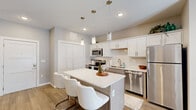 Located at 2620 W Sunshine St in Springfield, Missouri, this thoughtfully designed 2-bedroom, 2-bathroom residence offers a cohesive blend of modern style and functional living across a single floor. The open-concept kitchen serves as the heart of the home, showcasing white and taupe cabinetry, a classic subway tile backsplash, stainless steel appliances, and a central island with seating for multiple guests, illuminated by a trio of elegant pendant lights. Wood-look flooring flows throughout the main living areas, adding warmth and continuity to the space. The living room offers a comfortable, well-proportioned layout with a ceiling fan and neutral-toned walls that invite natural light. Both bedrooms are serene retreats, featuring plush carpeting, natural light from well-placed windows, and ceiling fans. The primary bedroom is generously sized, providing ample space for furnishings and relaxation. The bathrooms are finished with taupe cabinetry, white countertops, and light flooring, with the primary bath offering an extended vanity and access to a walk-in closet area. Two additional closets throughout the residence provide excellent storage. The overall aesthetic is clean, modern, and move-in ready.