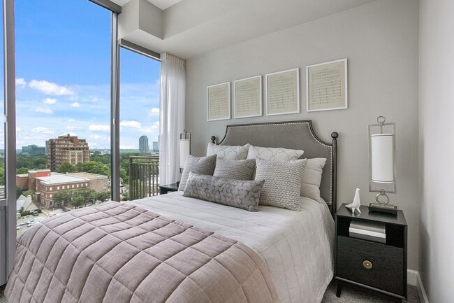 A serene bedroom retreat filled with natural light, featuring expansive windows, inviting textures, and a thoughtfully designed space for rest and recharge - The Residence Buckhead Atlanta