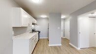 Located at 3170 Cleveland Ave in Columbus, Ohio, this 1-bedroom, 1-bathroom unit offers a clean, modern aesthetic defined by neutral gray walls, light-toned wood-style flooring, and crisp white trim carried consistently throughout. The open living room is bright and welcoming, with two windows that invite natural light and provide outdoor views, complemented by a wall-mounted HVAC unit for year-round comfort. The kitchen is thoughtfully designed with white shaker-style cabinetry, marble-look countertops, a stainless steel sink, a gas range, and a full-size refrigerator — offering efficient functionality in a well-organized galley layout. A hallway connects the main living areas to the private spaces, including a dedicated closet for additional storage. The bedroom is a comfortable, well-proportioned room featuring two windows with outdoor views, a wall-mounted HVAC unit, and a sliding-door closet with built-in shelving for organized storage. The bathroom features a white vanity with an undermount sink, brushed nickel fixtures, a rounded mirror with overhead lighting, and a full tub-shower combination — all finished in a cohesive, contemporary style. Light-colored flooring flows seamlessly throughout the entire unit, reinforcing a bright and cohesive feel.