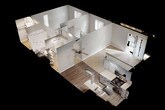 This single-floor residence offers a well-organized layout across a comfortably sized footprint. The living area is bright and open, featuring plush wall-to-wall carpeting, neutral gray walls, and a sliding glass door dressed with vertical blinds that allows abundant natural light and outdoor access. A ceiling fan overhead adds both function and a subtle design element, while wood-look vinyl flooring marks the transition into the kitchen and dining space.

The kitchen is efficiently designed with gray cabinetry, light stone-patterned countertops, stainless steel appliances including a refrigerator, dishwasher, gas range, and microwave, as well as a single-basin sink. Overhead flush lighting keeps the space well-illuminated.

The bedroom is carpeted and generously proportioned, featuring a window with views to the exterior, a closet, and an additional door leading to a walk-through or secondary space. The textured ceiling continues throughout the unit, maintaining a consistent aesthetic.

The bathroom includes a full tub and shower combination with clean white surrounds, brushed nickel fixtures and towel bars, and a standard toilet. The overall ambiance of the unit is clean, neutral, and move-in ready.