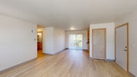 Located at 133 N 29th Ave in Cornelius, Oregon, this single-floor, 2-bedroom, 2-bathroom home offers a practical and comfortable layout. Light wood flooring flows throughout the main living areas, lending a clean and cohesive aesthetic, while a central hallway connects all rooms efficiently.

The spacious living room is bright and open, benefiting from natural light through a large sliding glass door that leads to an outdoor area. The combined dining and kitchen space features warm-toned wood cabinetry with ample upper and lower storage, dark countertops, and white appliances including a range and refrigerator — all set on matching wood-look flooring.

Both bedrooms are carpeted and well-lit by windows with vertical blinds that frame views of the surrounding greenery. The primary bedroom offers a generous footprint with multiple closets for added storage. Each bathroom includes a vanity with wood cabinetry, dark countertops, and a wall-mounted mirror with overhead lighting.

A dedicated laundry room includes washer/dryer hookups, wire shelving, and a water heater, providing functional utility space. With five closets throughout, storage is plentiful. The home's neutral color palette, light flooring, and consistent finishes create a clean, move-in-ready environment.