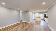 Located in the heart of Atlanta's desirable Buckhead neighborhood, this well-appointed one-bedroom, two-bathroom home offers a clean, modern aesthetic throughout its thoughtfully designed single-level layout. Rich wood-look flooring flows seamlessly through the living spaces, complemented by soft gray walls, crisp white crown molding, and recessed lighting that creates a bright and welcoming ambiance.

The kitchen is a standout feature, showcasing white cabinetry with glass-front upper panels, granite countertops with a classic subway tile backsplash, stainless steel appliances, and a central island with pendant lighting overhead. Natural light pours in through multiple windows, enhancing the open feel of the combined kitchen and living area.

The bedroom is a comfortable retreat, featuring a ceiling fan, a window with outdoor views of lush greenery, and direct access to an additional room. Both bathrooms are well-finished — one features a granite-topped vanity with warm wood cabinetry and natural light from frosted windows, while the second offers a clean, all-white tiled tub-shower combo with a modern vanity. A private balcony provides views of the Atlanta skyline, adding an urban flair to this well-located residence.