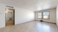 Located at 1735 W 19th St in Lawrence, Kansas, this single-floor, two-bedroom, one-bathroom residence offers a clean and functional layout designed for comfortable everyday living. The spacious living room is a highlight of the home, featuring light wood-look vinyl flooring, a textured ceiling, and large windows that invite generous natural light. A ceiling fan adds to the room's comfort and utility. The kitchen is well-appointed with white cabinetry, gray laminate countertops, and a full suite of stainless steel appliances, including a refrigerator, range, over-the-range microwave, and dishwasher, all set on matching light vinyl flooring. Both bedrooms are finished with plush wall-to-wall carpeting for a warm, comfortable feel. The generously sized primary bedroom includes a window with natural light, while the second bedroom also benefits from its own window. The bathroom features a white vanity with gray countertops, an undermount sink, and a chrome towel bar, maintaining the home's clean, neutral aesthetic. A hallway and dedicated closet complete the thoughtful floor plan. Neutral wall tones throughout the residence create a versatile backdrop ready to personalize.