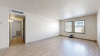 Located at 1735 W 19th St in Lawrence, Kansas, this single-floor, two-bedroom, one-bathroom residence offers a clean and functional layout designed for comfortable everyday living. The spacious living room is a highlight of the home, featuring light wood-look vinyl flooring, a textured ceiling, and large windows that invite generous natural light. A ceiling fan adds to the room's comfort and utility. The kitchen is well-appointed with white cabinetry, gray laminate countertops, and a full suite of stainless steel appliances, including a refrigerator, range, over-the-range microwave, and dishwasher, all set on matching light vinyl flooring. Both bedrooms are finished with plush wall-to-wall carpeting for a warm, comfortable feel. The generously sized primary bedroom includes a window with natural light, while the second bedroom also benefits from its own window. The bathroom features a white vanity with gray countertops, an undermount sink, and a chrome towel bar, maintaining the home's clean, neutral aesthetic. A hallway and dedicated closet complete the thoughtful floor plan. Neutral wall tones throughout the residence create a versatile backdrop ready to personalize.
