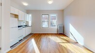 Located at 39 Charter Oak Place in Hartford, Connecticut, this single-floor unit offers a clean, well-maintained living environment with a cohesive design aesthetic. Rich hardwood flooring flows throughout the main living areas and bedrooms, adding warmth and character to the space.

The open living and kitchen area is bright and welcoming, with natural light pouring in through double windows and reflecting off the polished wood floors. The kitchen features white cabinetry, a dark countertop, a stainless steel sink, and white appliances, including a refrigerator and stove, all set against neutral walls. A classic cast-iron radiator provides efficient heating in the main room.

The bedroom areas are generously sized, finished in soft, neutral tones with the same warm hardwood flooring. White panel doors and clean white trim give the rooms a fresh, updated feel, and each space offers practical layout options for furniture placement.

The bathroom is neatly appointed with a full soaking tub and shower combination, a white vanity with a medicine cabinet mirror, and wood-look luxury vinyl flooring, creating a clean and functional environment.

Overall, the space presents a comfortable and practical layout with classic details like hardwood floors and a radiator heating system, complemented by modern, refreshed finishes throughout.