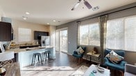 Located at 4200 N Falcon Dr in Goodyear, Arizona, this single-story residence offers a well-designed open-concept layout that seamlessly connects the kitchen, dining, and living areas. The living room is bright and welcoming, featuring wood-look flooring, a ceiling fan, and large windows with sliding glass door access to the outdoors, flooding the space with natural light. The kitchen is outfitted with dark espresso cabinetry extending to the ceiling for ample storage, granite countertops, stainless steel appliances including a refrigerator with ice maker, range, and built-in microwave, and a breakfast bar with seating. Each bedroom offers a comfortable retreat with soft accent-painted walls, natural light from windows, and wood-look flooring. The primary bedroom connects to a well-appointed en-suite bathroom featuring a dual-sink vanity with granite countertops, dark cabinetry, and a walk-in closet. A secondary bathroom mirrors the same refined finishes, including a granite-topped vanity and stylish fixtures. Consistent wood-look flooring and a neutral yet modern color palette of gray and warm beige tones unify the space, creating a cohesive and contemporary aesthetic throughout.