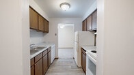 Located at 907 W Loire Ct in Peoria, Illinois, this single-floor unit offers a practical and functional layout designed for comfortable everyday living. The entry foyer welcomes you with durable wood-look plank flooring, setting a clean and understated tone throughout. The galley-style kitchen is efficiently laid out with dark wood cabinetry lining both walls, light-toned laminate countertops, a stainless steel sink, and white appliances including a refrigerator, electric range, and dishwasher. Wood-look plank flooring continues through the kitchen, which opens directly into the adjacent living area. The living space features plush carpeting and is highlighted by a ceiling fan and a large sliding glass door fitted with vertical blinds, allowing generous natural light and providing access to the outdoors. The bedrooms are carpeted and feature neutral walls, wood-toned baseboards, and windows with horizontal blinds that invite natural light. The bathroom is accessed through a wood-framed door and includes a full-size soaking tub and shower combination with clean white surrounds, a toilet, and wood-look plank flooring. Throughout the unit, the consistent use of warm wood tones and neutral finishes creates a cohesive and welcoming atmosphere.