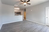 Located at 1164 Asherton Pl in El Paso, Texas, this single-story home offers a clean, modern aesthetic with a thoughtfully designed open-concept floor plan. The living area is bright and welcoming, finished with wood-look luxury vinyl plank flooring and neutral gray walls that lend a contemporary feel throughout. Ceiling fans with integrated lighting are present in multiple rooms, enhancing both comfort and style. The front entry opens into a spacious living room filled with natural light from large windows dressed with horizontal blinds.

The kitchen is seamlessly connected to the living space via a peninsula-style breakfast bar, making it ideal for everyday living and entertaining. Dark wood cabinetry is paired with granite-look countertops and stainless steel appliances, including an electric range and over-the-range microwave, creating a sleek and functional cooking environment.

The bedrooms continue the home's cohesive design with the same wood-look flooring, neutral walls, ceiling fans, and windows that invite ample natural light. The bathroom features a dark wood vanity with a granite-look countertop, wood-look tile flooring, and a full tub-shower combination with clean white tile surround. Overall, this home presents a well-maintained, move-in ready space with modern finishes and a practical single-floor layout.