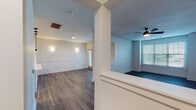 Located at 100 Village Circle Way in Durham, NC, this two-floor residence offers a well-designed layout with contemporary finishes and functional living spaces. The main level features an open-concept living and dining area adorned with durable hardwood-style flooring, wainscoting detail along the walls, and a ceiling fan for added comfort. A structural column adds architectural character to the space, which is brightened by multiple windows fitted with slatted blinds. The kitchen is a standout feature, boasting a peninsula with a white quartz countertop, an undermount sink, and stylish pendant lighting. Gray shaker-style cabinetry pairs with stainless steel appliances, including a refrigerator, range, and microwave. The bathrooms are finished with gray vanity cabinetry, black hardware accents, framed mirrors, and hardwood-style flooring, with one bathroom offering a tiled shower-tub combination. Bedrooms are carpeted and generously sized, with large windows that invite natural light. Multiple walk-in closets with wire shelving systems provide ample storage. A dedicated laundry area with a full-size washer and dryer adds everyday convenience. The overall ambiance is clean, neutral, and move-in ready.