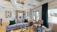 Located along I-35W North in Shoreview, Minnesota, this single-floor community space is thoughtfully designed with upscale finishes and a welcoming ambiance. The layout flows seamlessly from a well-appointed entryway foyer—anchored by a lantern-style chandelier and a round accent table—into open social and lounge areas that invite gathering and conversation.

The main lounge is a standout, featuring striking coffered ceilings that add architectural depth and elegance. A wall-mounted fireplace framed in detailed patterned tile serves as a dramatic focal point, complemented by a large flat-screen TV above. Rich emerald drapery panels frame windows that allow natural light to fill the space, and French doors provide access to an outdoor area. Light hardwood flooring runs throughout, enhancing the bright, airy feel.

A dining area with a live-edge wood table connects naturally to the lounge, maintaining the open, communal character of the space. The kitchenette is equipped with stainless steel appliances, light wood cabinetry, a herringbone green tile backsplash, and a mounted TV—ideal for everyday use. The 3D scan reveals a generously scaled footprint with well-defined corridors connecting each zone cohesively.