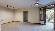 This single-floor residence offers a thoughtfully designed open-concept layout that seamlessly connects the living area to the kitchen. The spacious living room features plush wall-to-wall carpeting, warm wood-trimmed doorways and windows, and a ceiling fan with integrated lighting. Sliding glass doors provide direct access to a private balcony, allowing natural light to flow into the space.

The kitchen is well-equipped with dark espresso cabinetry, granite countertops, stainless steel appliances, and a peninsula with open shelving underneath. Pendant lights and track lighting illuminate the space, while large-format tile flooring adds a clean, modern touch.

The bedrooms continue the carpeted aesthetic, each featuring ceiling fans, wood-framed windows with blinds, and ample natural light. One bedroom offers corner windows for additional brightness and outdoor views.

The bathroom is finished with a dark vanity, granite countertop, undermount sink with a brushed nickel faucet, a framed mirror, and large-format tile flooring. A soaking tub, separate toilet area, and tall storage cabinetry complete the functional layout.

A dedicated laundry area with dark cabinetry, granite countertop, and tile flooring adds everyday convenience. Throughout the residence, neutral tones and consistent finishes create a cohesive and inviting atmosphere.