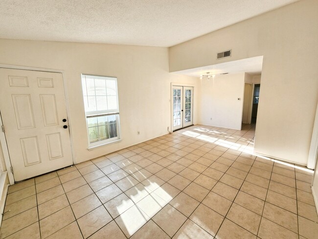 Living room / den area with high ceiling and plenty of natural light. - 111 Meteor Dr