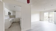 Located at 924 S Carondelet St in Los Angeles, this 1-bedroom, 2-bathroom residence offers a thoughtfully designed single-floor layout with a clean, neutral aesthetic throughout. The open-concept living and kitchen area serves as the heart of the home, where light gray laminate flooring flows seamlessly underfoot. The kitchen is well-appointed with white shaker cabinetry, light quartz countertops, a bold gold-tone faucet, stainless steel built-in microwave, and a dishwasher — all centered around a generous peninsula ideal for dining or entertaining. The living area is bright and airy, featuring a textured ceiling and a sliding glass door that opens to a private balcony with outdoor views. The spacious primary bedroom is carpeted for comfort and is directly connected to a dedicated bathroom featuring a wide vanity with an undermount sink and large mirror. A second bathroom includes a tub-shower combination. The bedroom is bathed in natural light from a window with vertical blinds and offers easy access to the kitchen area. Throughout the residence, clean white walls, textured ceilings, and consistent finishes create a cohesive and move-in-ready environment well-suited for comfortable urban living in Los Angeles.